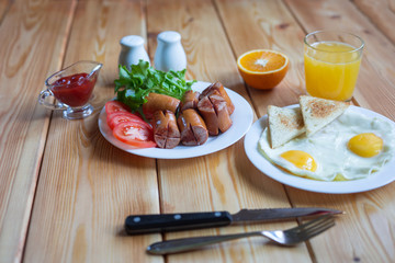 Orange juice, Two eggs and sausage for healthy breakfast.