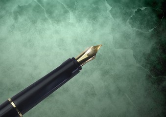 Fountain pen gold tip against green classic background