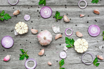 garlic, red onion, parsley and pepper on rustic wooden background