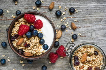 homemade granola with greek yogurt, nuts and fresh berries in a bowl