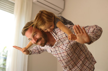 Young dad with cute daughter at home.