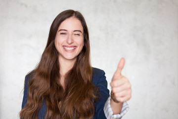 businesswoman showing thumbs up and winks