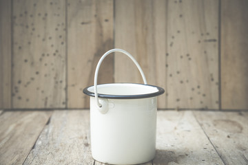 bucket of water on wood background, vintage filtered Images