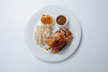 baked pork knuckle served with braised cabbage