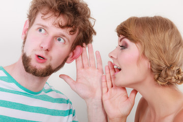 Woman telling an astonished man some secrets