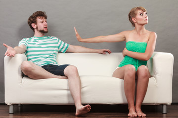 Man and woman in disagreement sitting on sofa