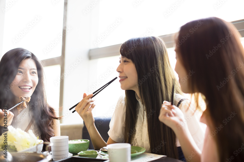 Wall mural happy young women group eating hot pot.