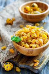 Dried grapes and dyed eggs in wooden bowls.