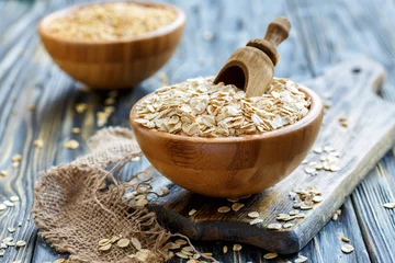 Rolgordijnen Wooden scoop in a bowl with oat flaks. © sriba3