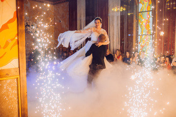 Happy bride and groom and their first dance, wedding in the elegant restaurant with a wonderful light and atmosphere - obrazy, fototapety, plakaty