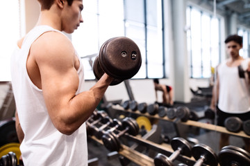 Hispanic man in gym, working out with weights