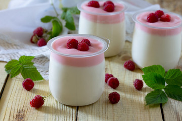 Homemade yogurt with raspberries on a table in a rustic style.