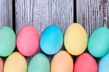 Two rows of colored eggs. Easter eggs, gray wood texture.