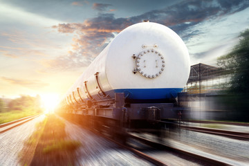 Naklejka premium Zbiorniki z gazem transportowane koleją o zachodzie słońca