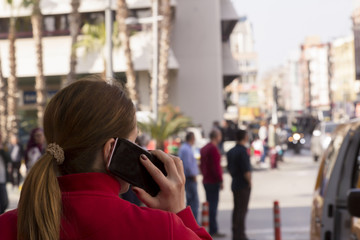 woman on phone walking in busy street