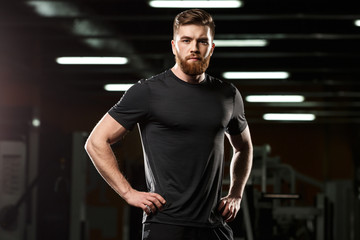 Fototapeta na wymiar Concentrated handsome sports man posing in gym