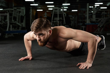 Obraz premium Concentrated young strong sports man make sport exercise