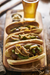 three bratwurst sausages with grilled onions and bell peppers