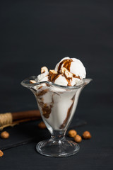 Vanilla ice cream with chocolate topping on the wooden background. Shallow depth of field.