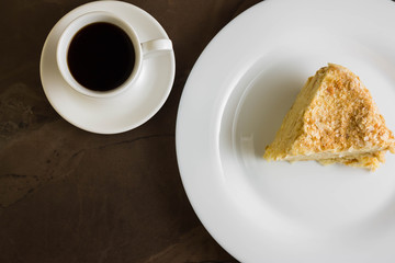 Piece of cake with butter cream on a white plate. Napoleon cake. A delicious dessert.