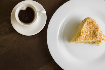 Piece of cake with butter cream on a white plate. Napoleon cake. A delicious dessert.