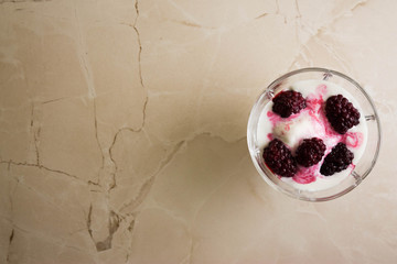 Ice cream with blackberries on a marble table. Delicious dessert.