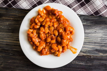 Beans in tomato in a white plate. A delicious dish.