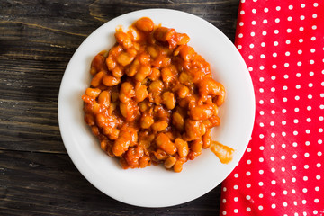 Beans in tomato in a white plate. A delicious dish.