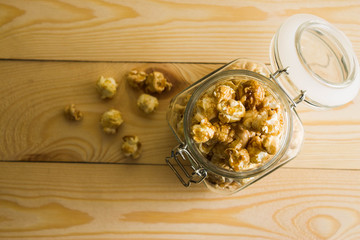 Popcorn in a glass jar on a wooden table.