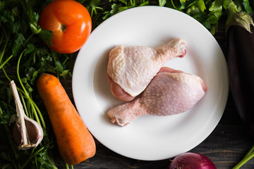 Chicken legs with fresh vegetables. Preparation for cooking.