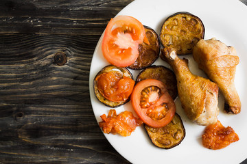 Fried chicken legs with vegetables. Tasty and nutritious dish.