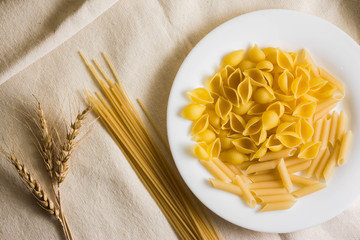 Raw pasta on a white sacking. Different types of pasta.
