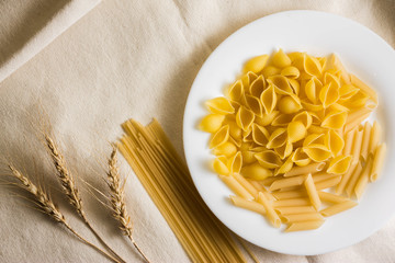 Raw pasta on a white sacking. Different types of pasta.