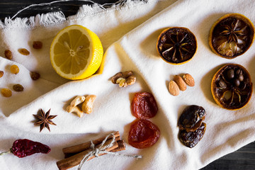 Dried slices of lemon, coffee beans, cinnamon, leaf tea, dried fruits and nuts on a wooden table. Natural product.