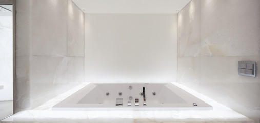large bath tub in the bathroom lit marble, nobody