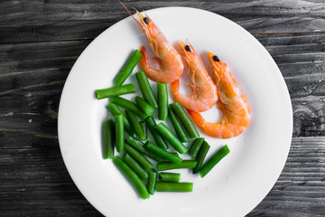 Shrimps with vegetables on a wooden table in rustic style