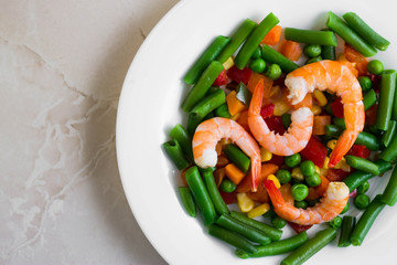 Shrimps with vegetables on a wooden table in rustic style