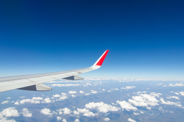 Fototapeta na wymiar wing airplane with bluesky and clouds from window