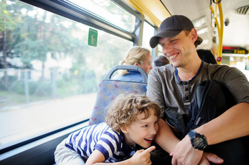 The young man goes by the bus together with the son.
