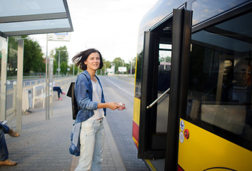The young woman the brunette stands on the bus stop.