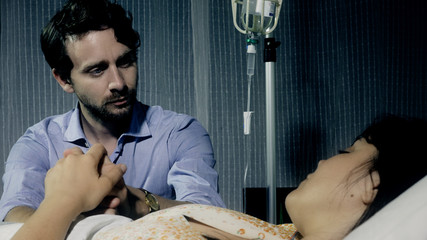 husband at hospital in night with his sick ill woman