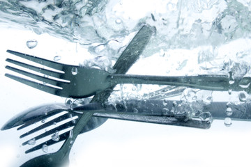 Dish washer, kitchen items in the water and bubbles