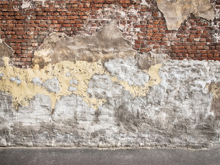 Old brick wall with peeling plaster, dark background for design