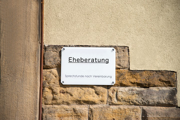 Ein Schild einer Eheberatung an einer Hauswand