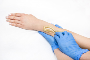 Obraz premium Epilation sugar processes woman passes in a beauty salon 