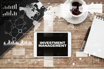 Tablet on desktop with investment management text.