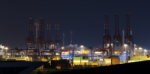 Harbor of Hamburg with cranes and containers at night