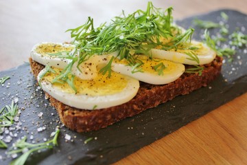 Traditional danish open sandwich with egg, sour cream, dill, salt and pepper
