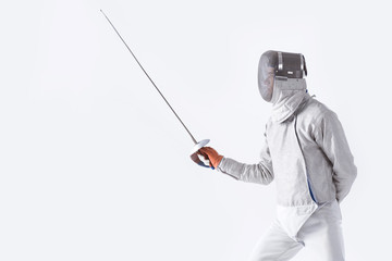 side view of fencer in uniform training with rapier on white