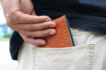 man picking wallet from jeans pocket